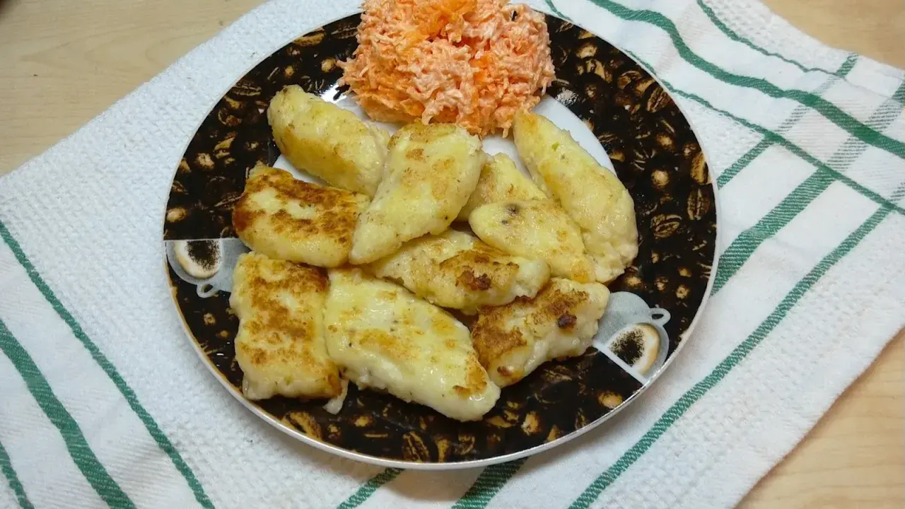 Usmażone pierogi ruskie z serem i ziemniakami, podane z surówką z marchewki.