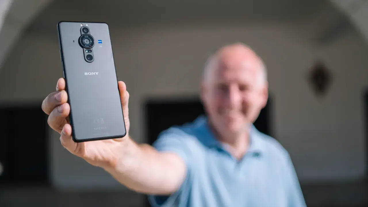 Mężczyzna prezentuje tył telefonu Sony Xperia Pro z potrójnym aparatem.