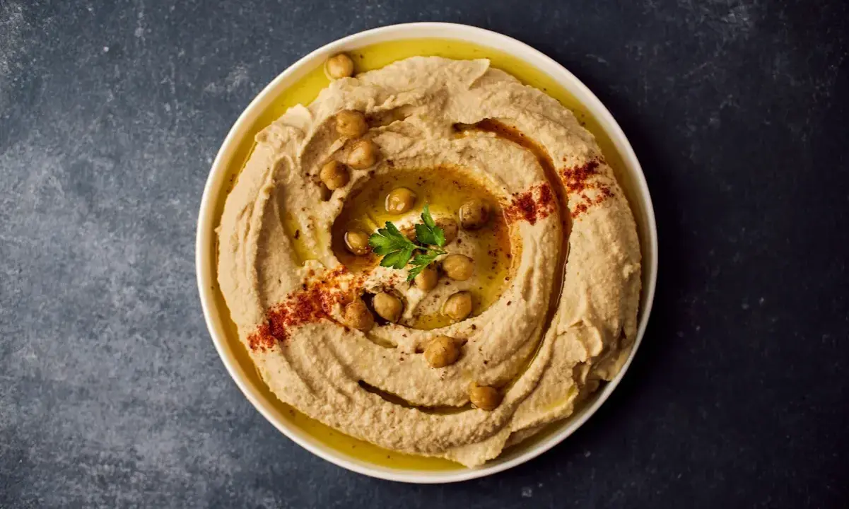 Krämig hummus med kikärtor, olivolja och paprikapulver. Ett perfekt hummus recept för alla tillfällen.