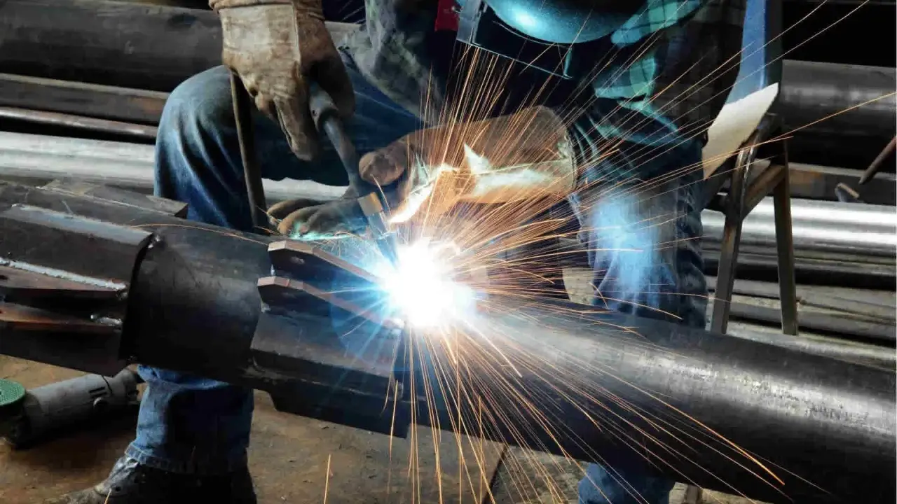 Un saldatore crea un legame forte, il vero significato del welding. Scintille luminose illuminano il metallo.