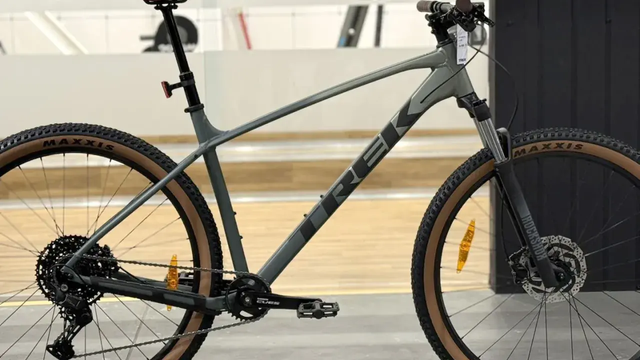 Szary rower górski Trek Marlin 6 z brązowymi oponami Maxxis, gotowy na przygodę.