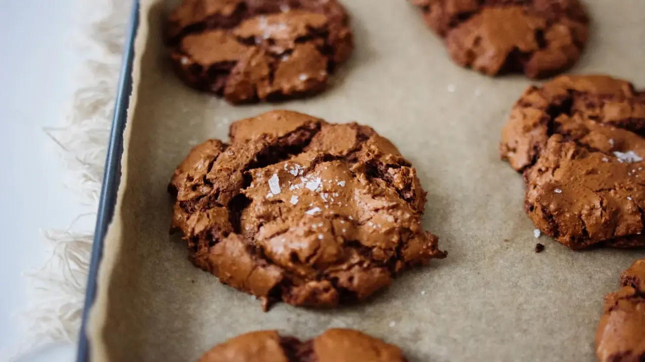 Saftige schoko cookies mit Meersalzflocken auf Backpapier, bereit zum Genießen.