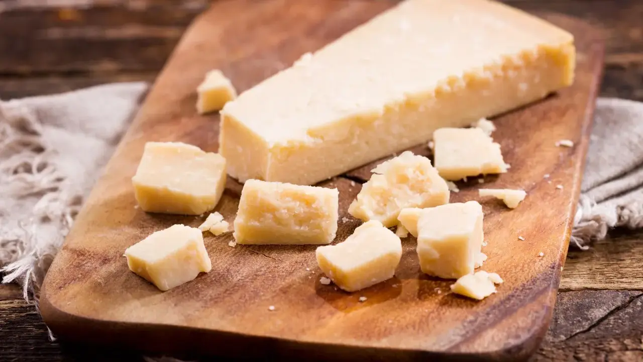 Parmesan-Stücke auf Holzbrett. So einfach kann parmesan einfrieren sein, um den Geschmack zu bewahren.
