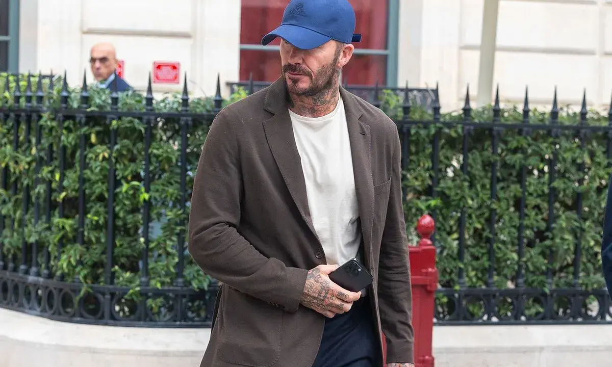Uomo con cappellino blu e giacca marrone, dimostra che blu e marrone stanno bene insieme.