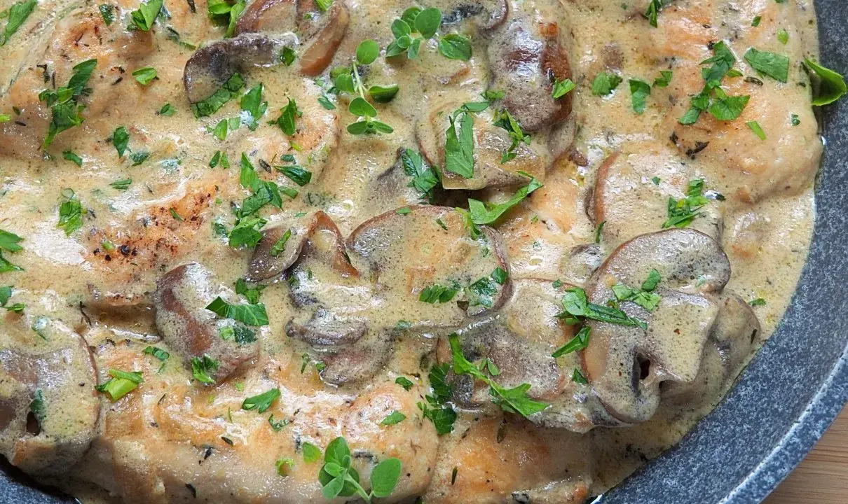 Polędwiczki w sosie pieczarkowym, kremowe i aromatyczne, posypane świeżą natką pietruszki.