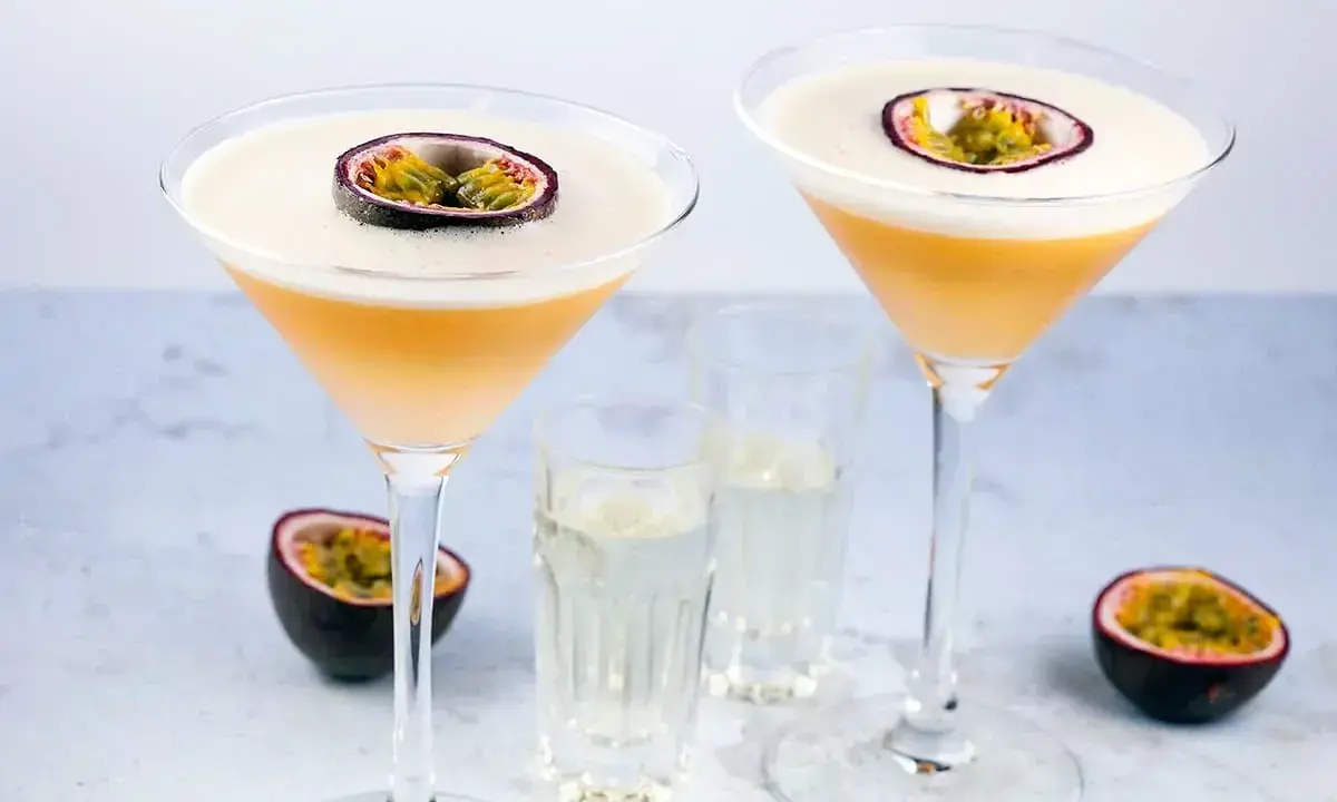 Dwa drinki Pornstar Martini, ozdobione połówką marakui, z kieliszkami z dodatkowym shotem. Idealne, by dowiedzieć się, jak pić.
