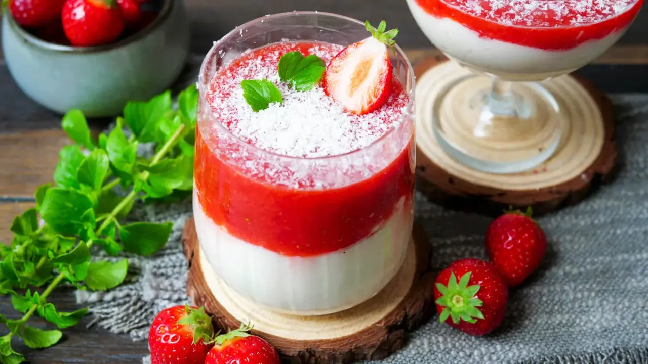 Zwei leckere eistörtchen mit Erdbeeren und Kokosraspeln, garniert mit Minze und frischen Erdbeeren.