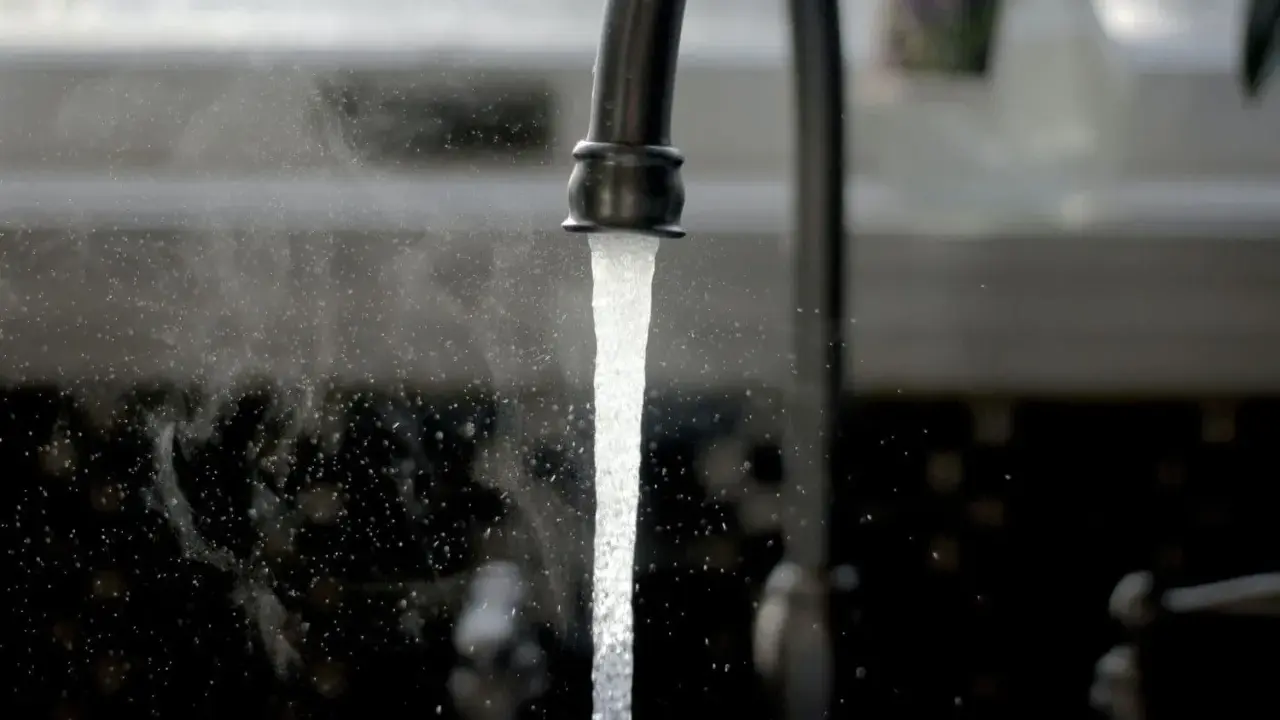 Un robinet ouvert, l'eau coule. Une image symbolisant l'ouverture du compteur d'eau pour un locataire.
