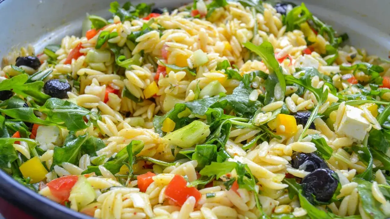 Ein bunter Kritharaki Salat mit Rucola, Oliven, Feta und Gemüse. Perfekt für einen leichten Genuss.