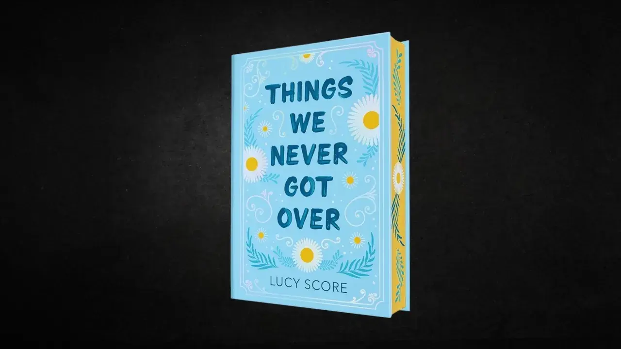 Okładka książki "Things We Never Got Over" Lucy Score. Jasnoniebieska okładka z motywem stokrotek i liści.