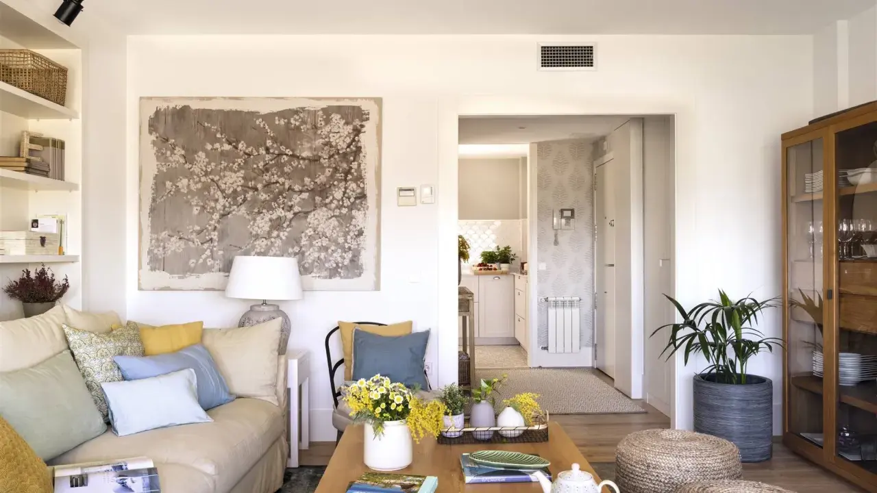 Ideas para decorar un salón moderno y elegante: sofá beige, mesa de centro de madera, arte floral, plantas y detalles acogedores.