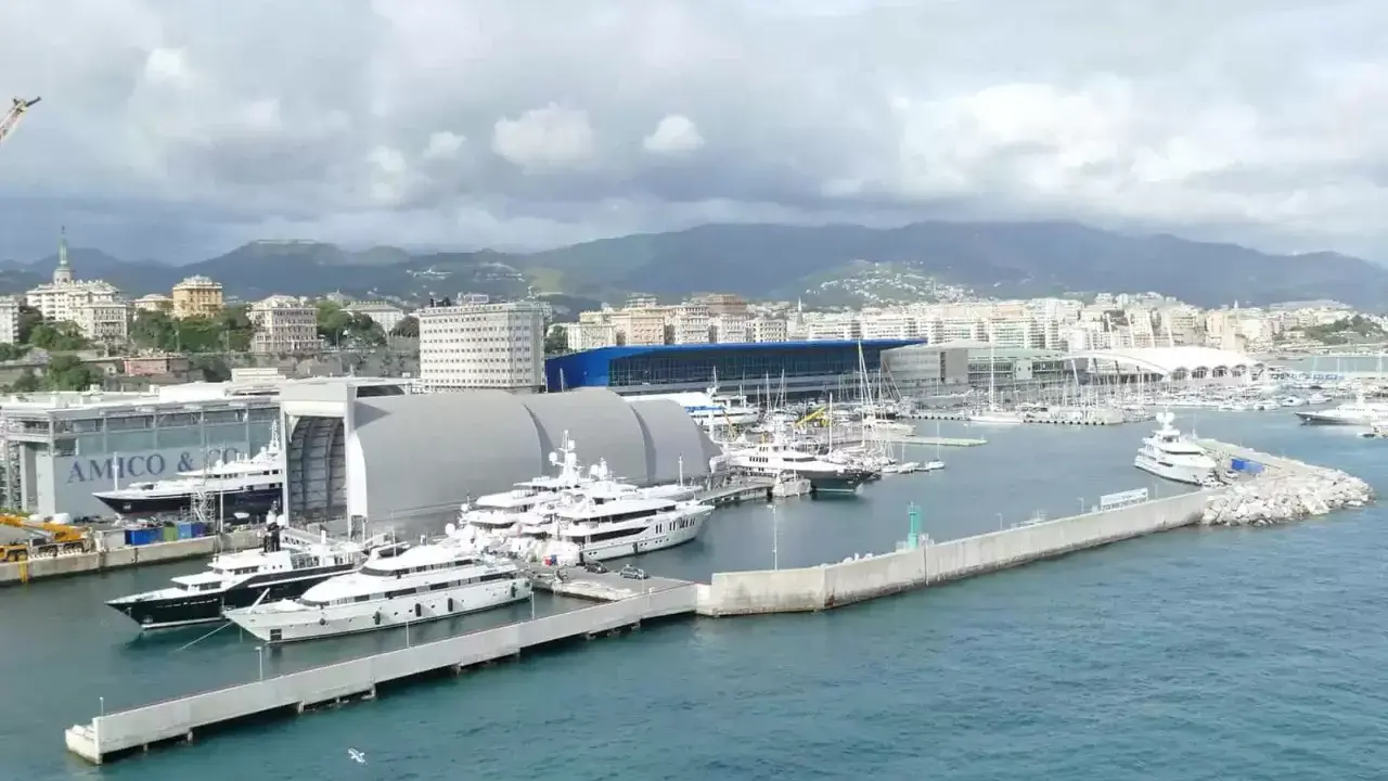Porto con yacht di lusso ormeggiati, sullo sfondo la città e le montagne. Un'immagine che fa sognare, ma il costo medio crociera è da valutare.