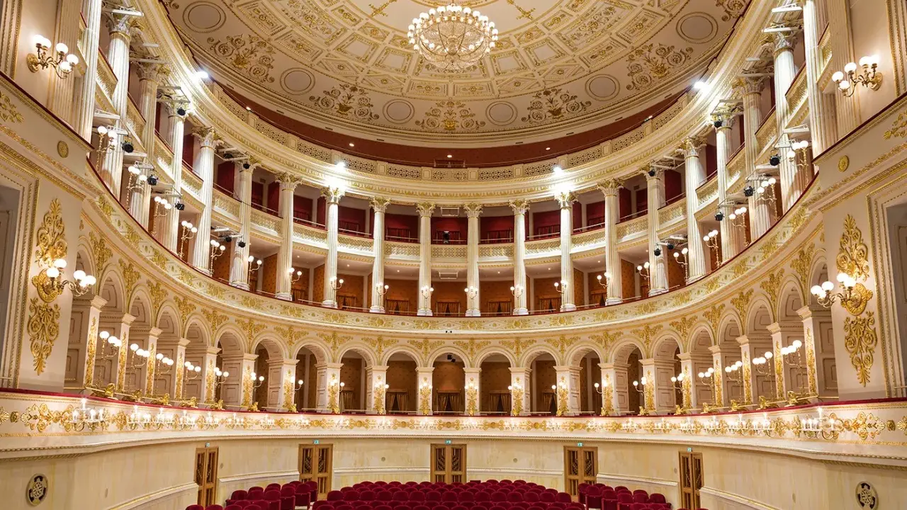 Interni sfarzosi del teatro Amintore Galli, con poltrone rosse e decorazioni dorate. Scopri i prossimi eventi!