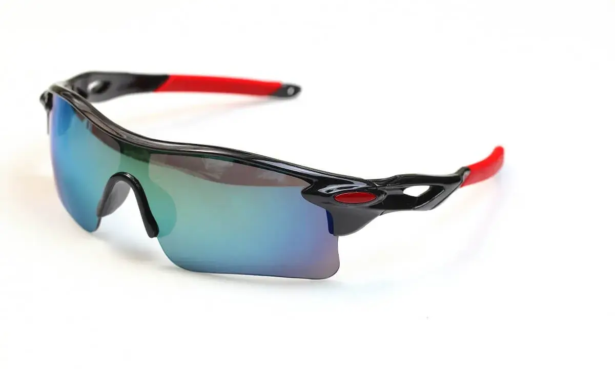 Sportowe okulary rowerowe z lustrzanymi soczewkami i czerwonymi zausznikami. Idealne, gdy zastanawiasz się, jakie okulary na rower wybrać.
