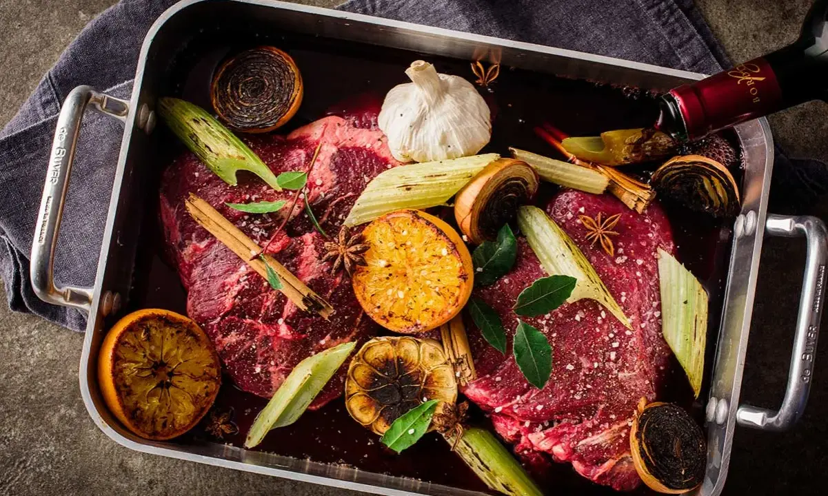 Råstekta köttbitar med apelsin, lök, vitlök och stjärnanis i en form. Ett perfekt minutfile recept för en festmåltid.
