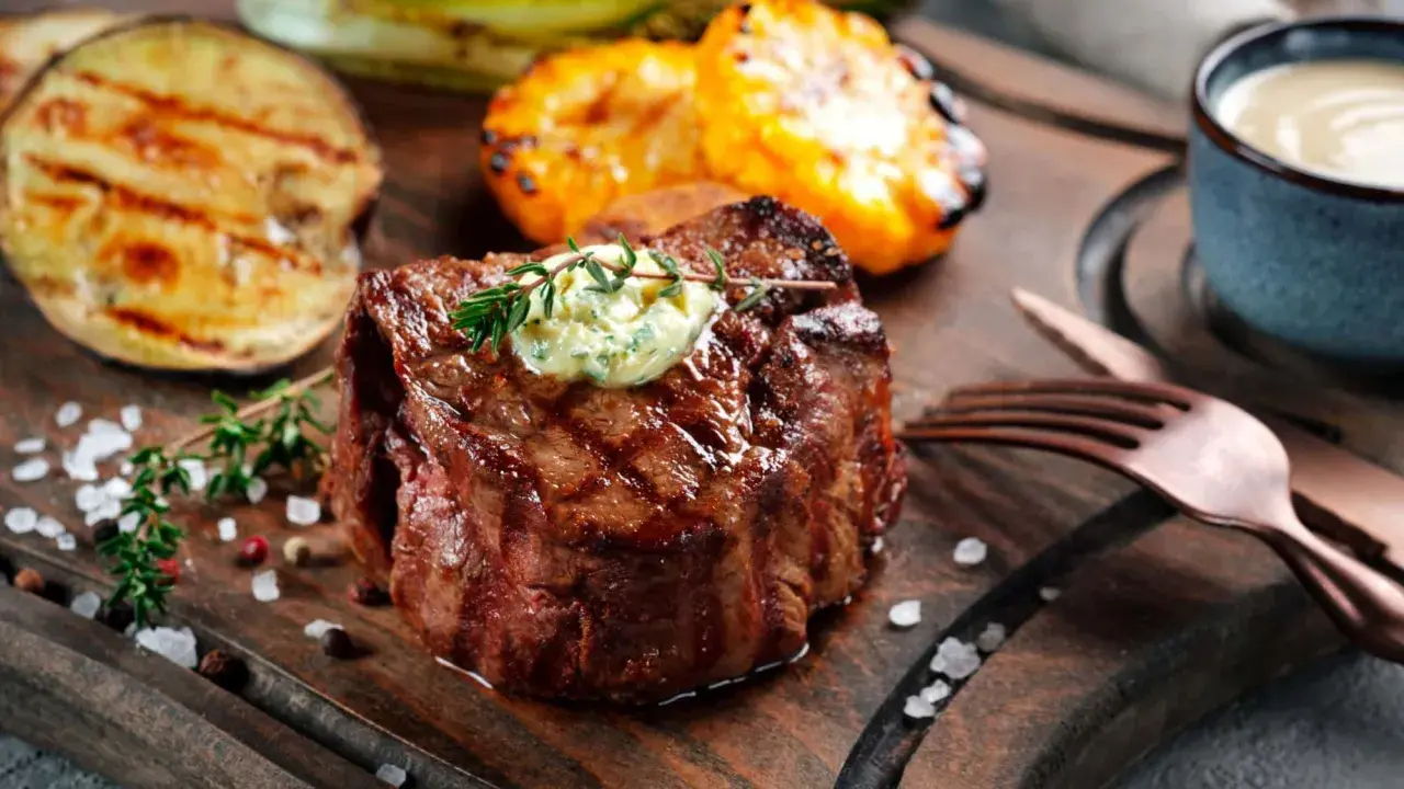 Perfekt gegrilltes Fleisch mit Kräuterbutter, dazu gegrilltes Gemüse und eine Dip-Schale.