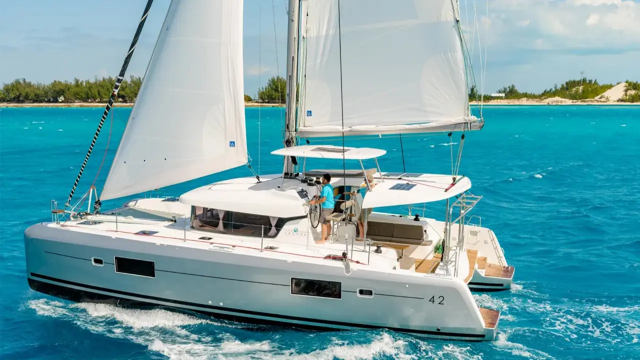 Catamaran Lagoon 42 naviguant sur des eaux turquoise. La fiche technique de ce voilier de luxe promet des croisières inoubliables.