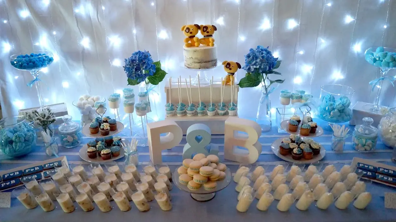 Mesa de dulces para una boda sencillo: pastel con perritos, cupcakes, macarons y postres individuales.