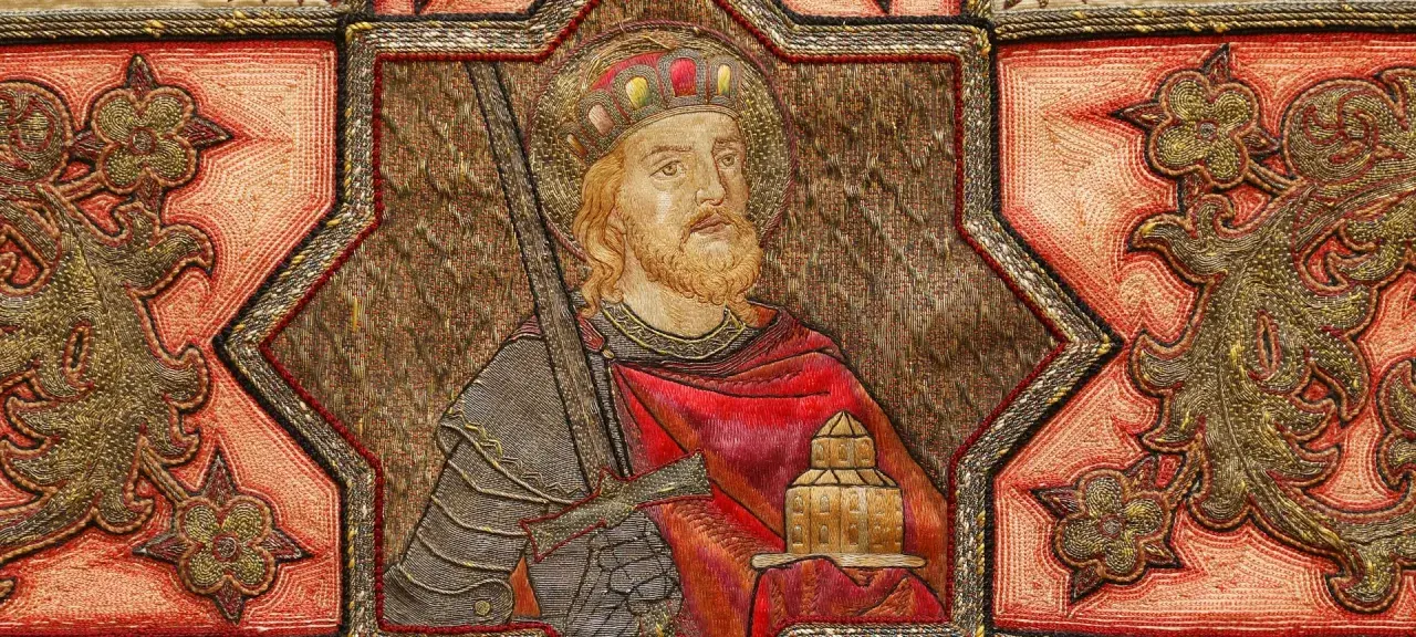 Ein König mit Krone und Bart, der ein Schwert und ein Gebäude hält, umgeben von Ornamenten. Möglicherweise eine Darstellung aus dem Jahr 800 nach Christus.