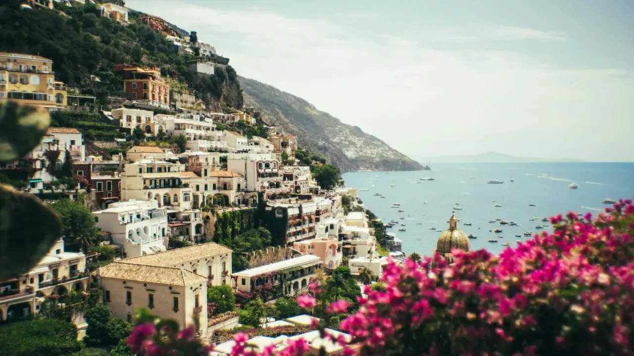 Positano, uno dei paesi più belli della Costiera Amalfitana, con case bianche aggrappate alla scogliera e il mare blu pieno di barche.