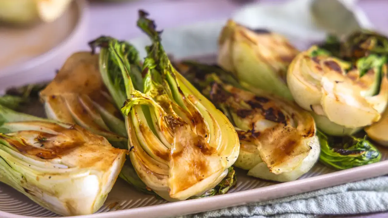 Halbierte Pak Choi-Stücke, die auf einem Teller mit Grillspuren liegen. Köstlich und gesund!