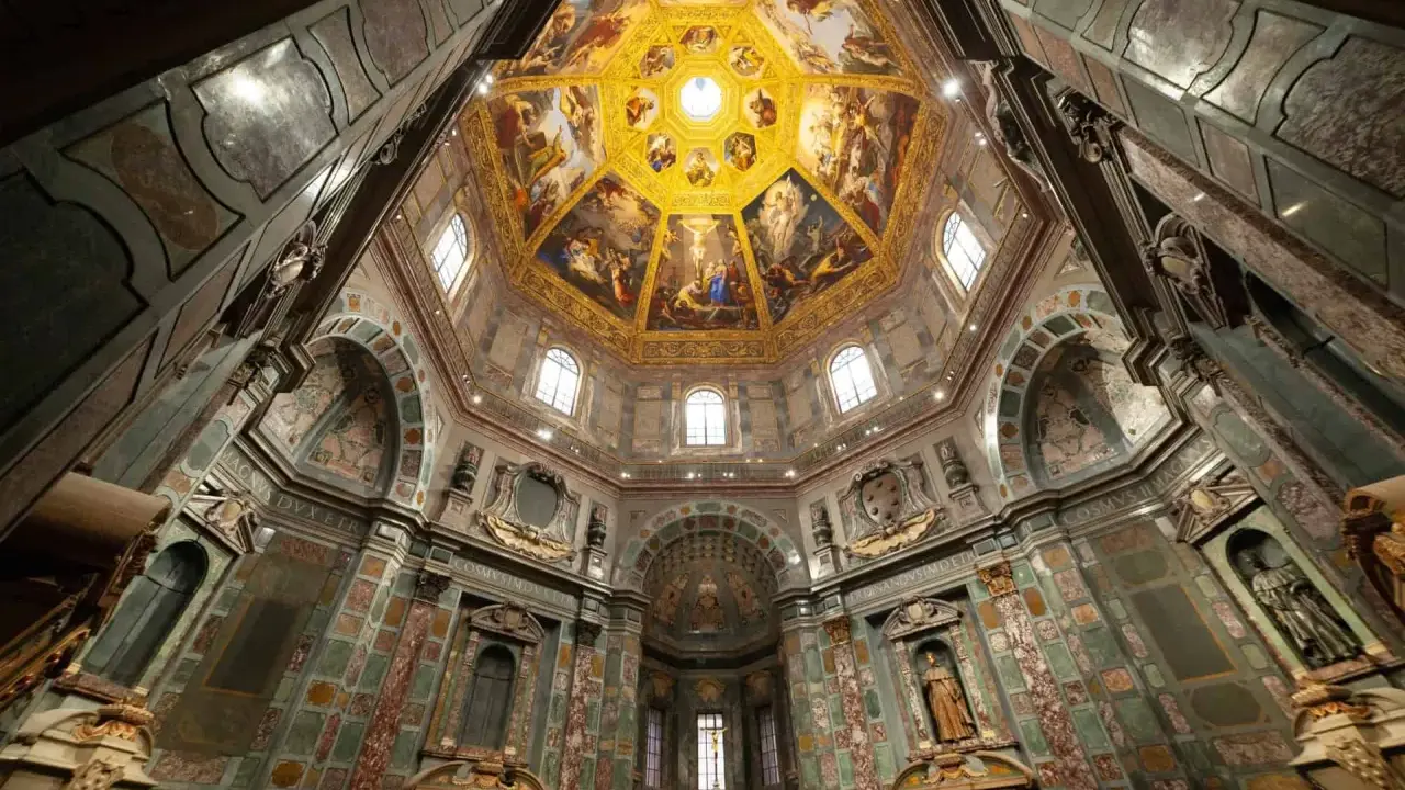 Intérieur de la Chapelle des Médicis, dôme orné de fresques dorées et de peintures religieuses, murs décorés de marbre et de sculptures.