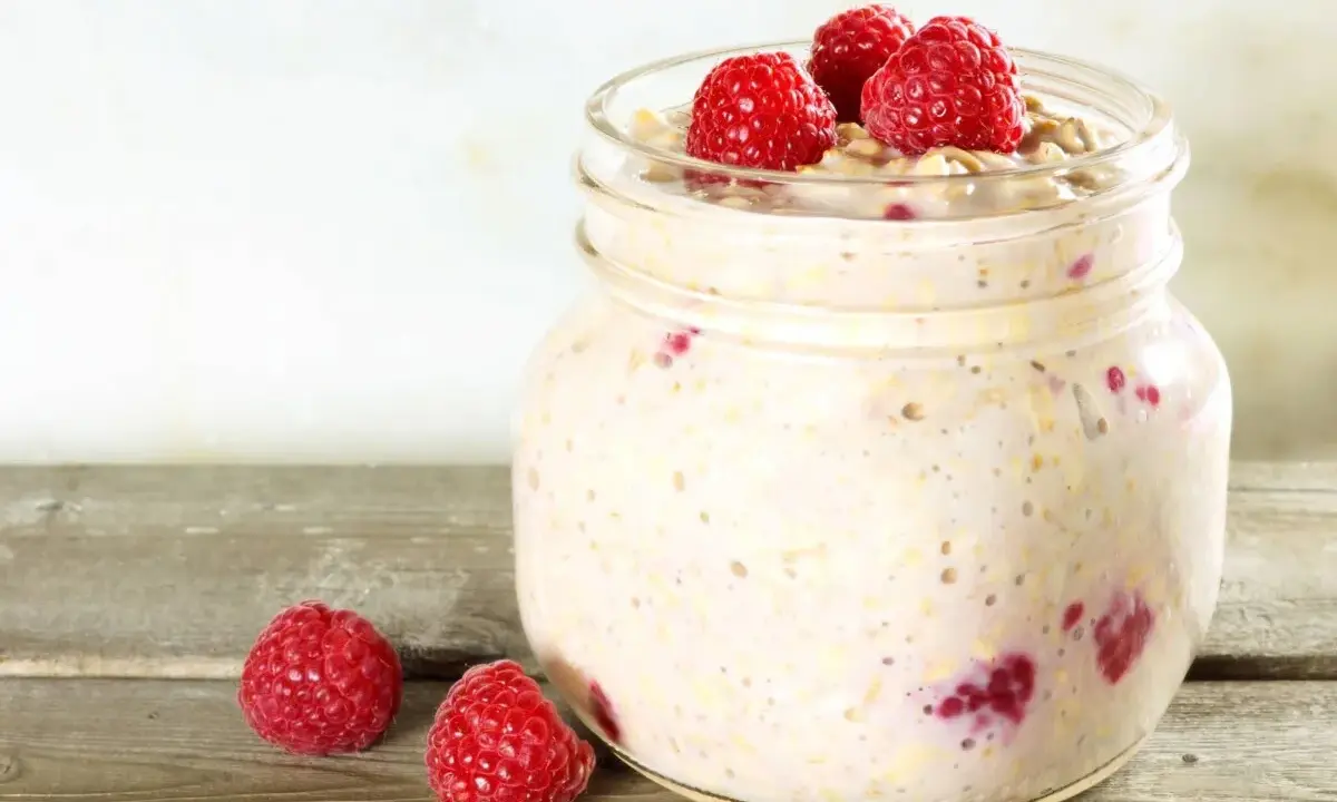 Overnight oats med proteinpulver och hallon i burk, perfekt för en snabb och näringsrik frukost.