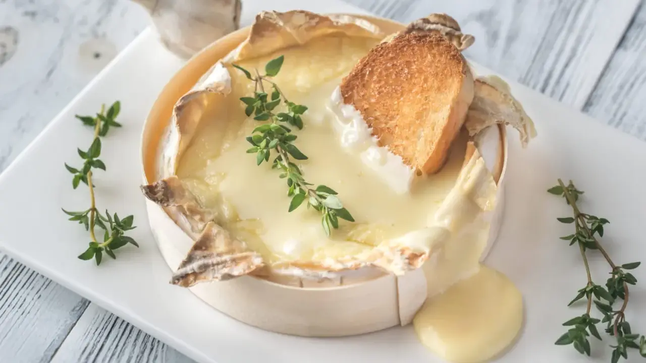 Un camembert coulant, spécialité normandie, servi avec du pain grillé et du thym. Un délice !