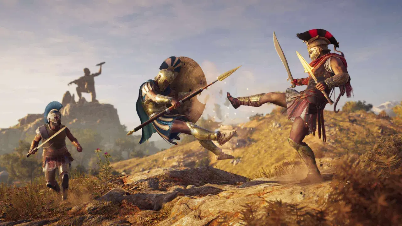 Spartanie walczą w Assassin's Creed Odyssey. Jeden z nich wykonuje kopnięcie, drugi blokuje tarczą.