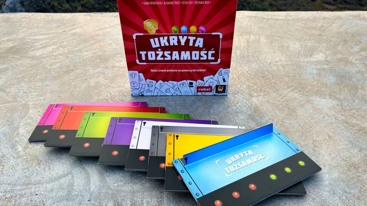 Gra "Ukryta tożsamość" w pudełku i kolorowe karty do gry.