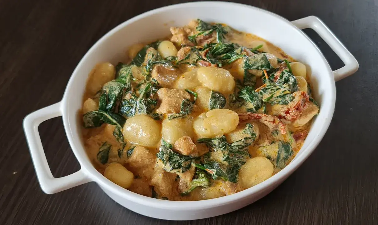 Pyszne gnocchi z kurczakiem w kremowym sosie ze szpinakiem i suszonymi pomidorami.