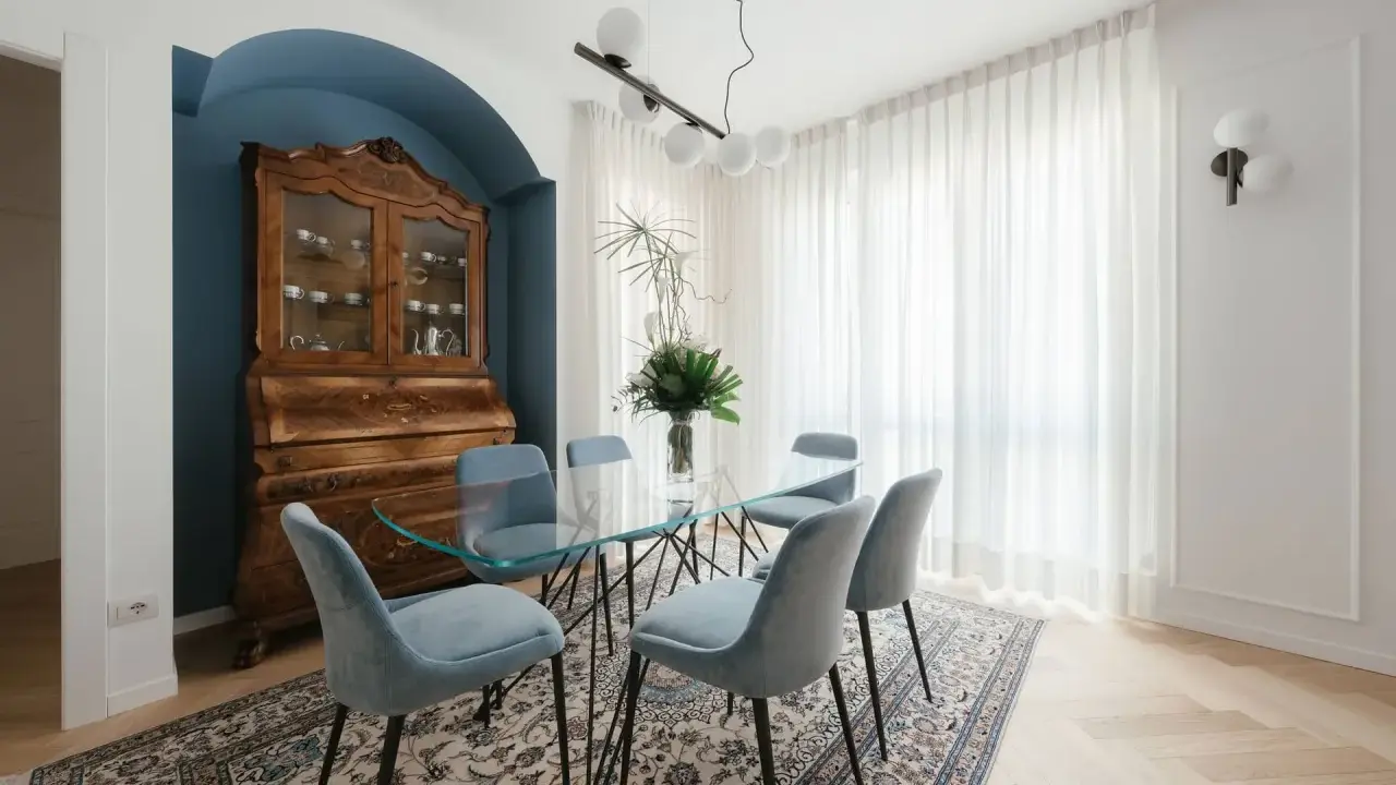 Un soggiorno classico con un mobile antico e un tavolo in vetro. I colori delle pareti, un blu intenso, creano un'atmosfera elegante.