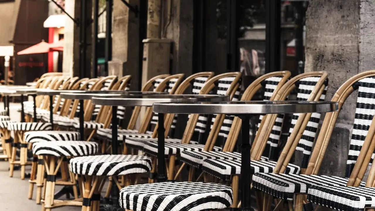 Terrasses parisiennes avec chaises et tabourets rayés, prêts à accueillir les gourmands pour déguster les spécialités paris.