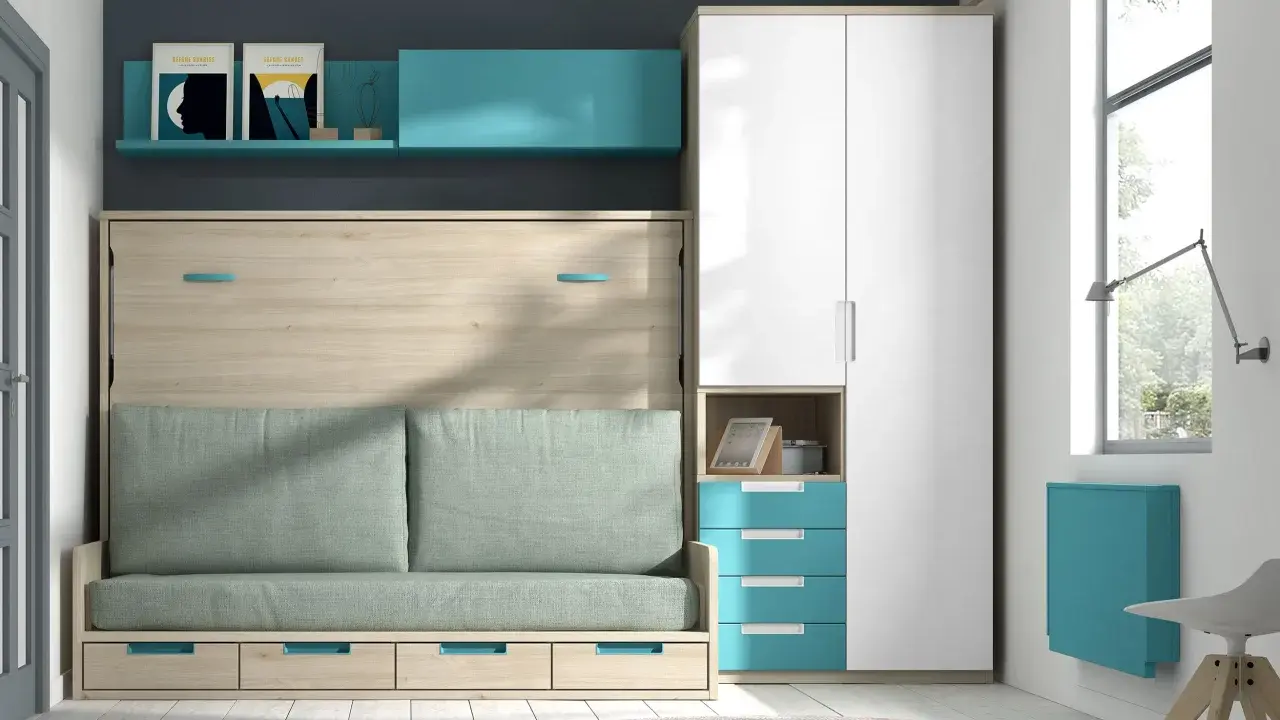 Mueble comedor con cama abatible, sofá verde y armario blanco. Estantería azul con cuadros.