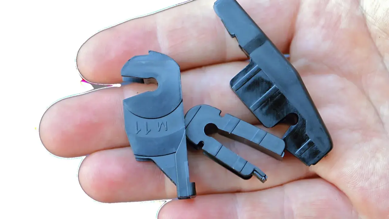 Różne typy mocowań wycieraczek samochodowych w dłoni. Widać adaptery do piór wycieraczek.