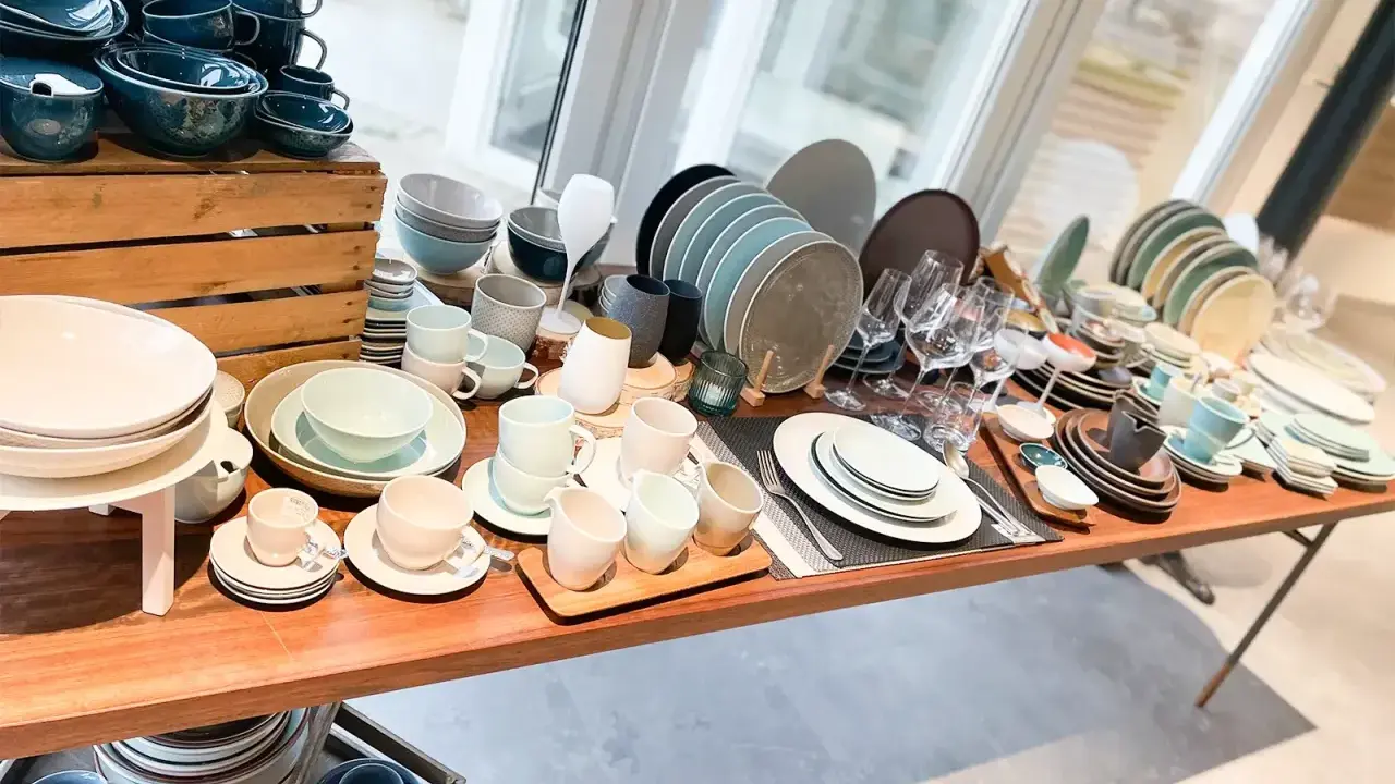 Vielfältiges Gastronomiegeschirr aus Keramik und Glas, darunter Teller, Schüsseln, Tassen und Gläser.