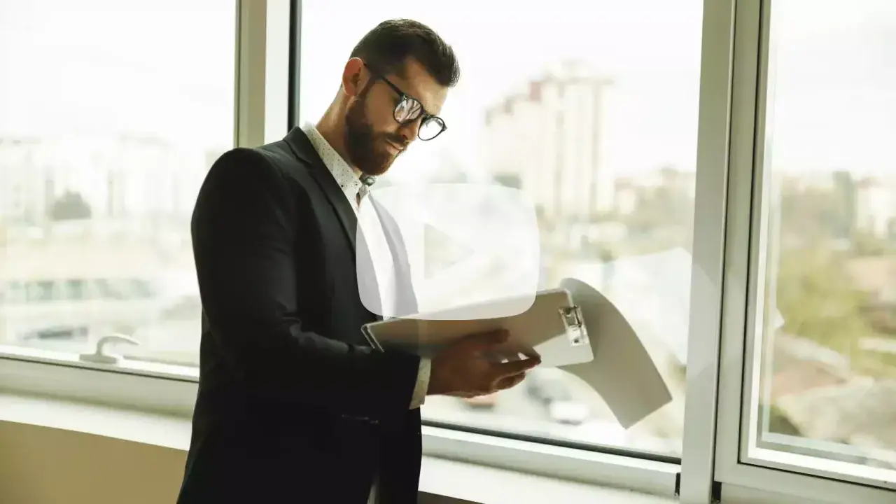 Hombre con gafas revisa documentos. Explica qué es un aval bancario para alquiler, una garantía para el arrendador.