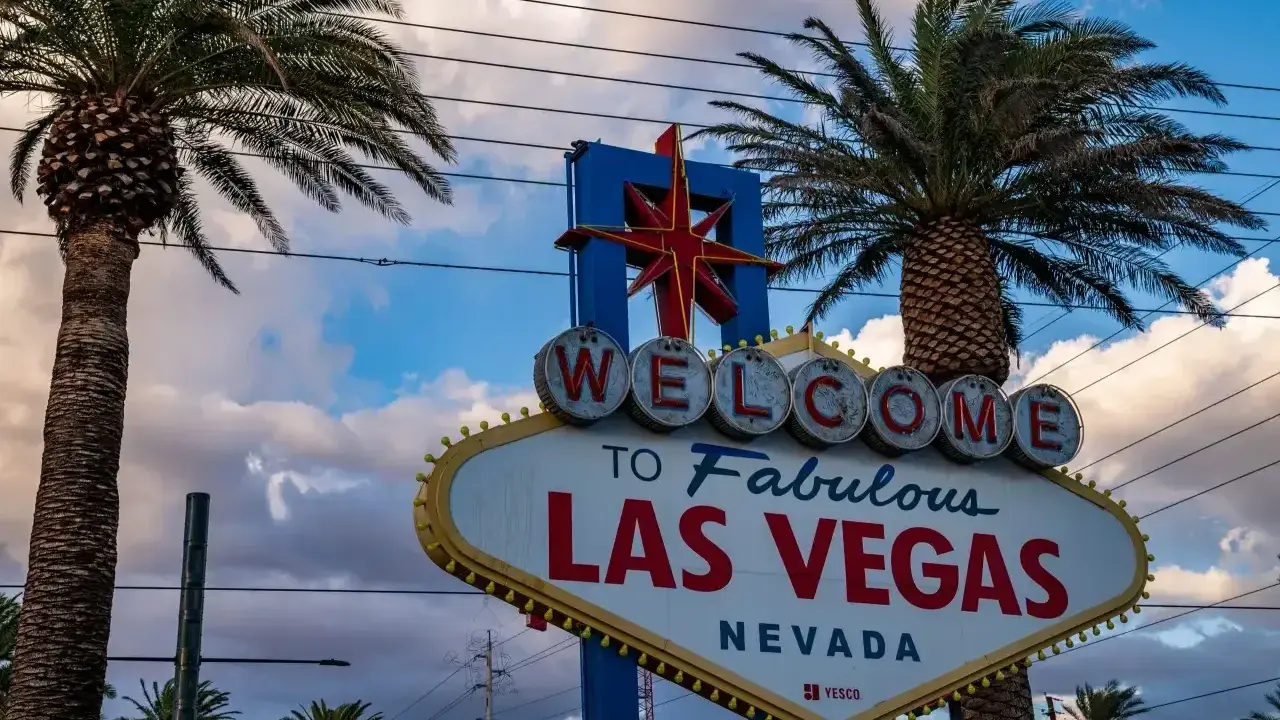 Słynny znak "Welcome to Fabulous Las Vegas" w Nevadzie, stan, w którym znajduje się to miasto rozrywki, otoczony palmami.