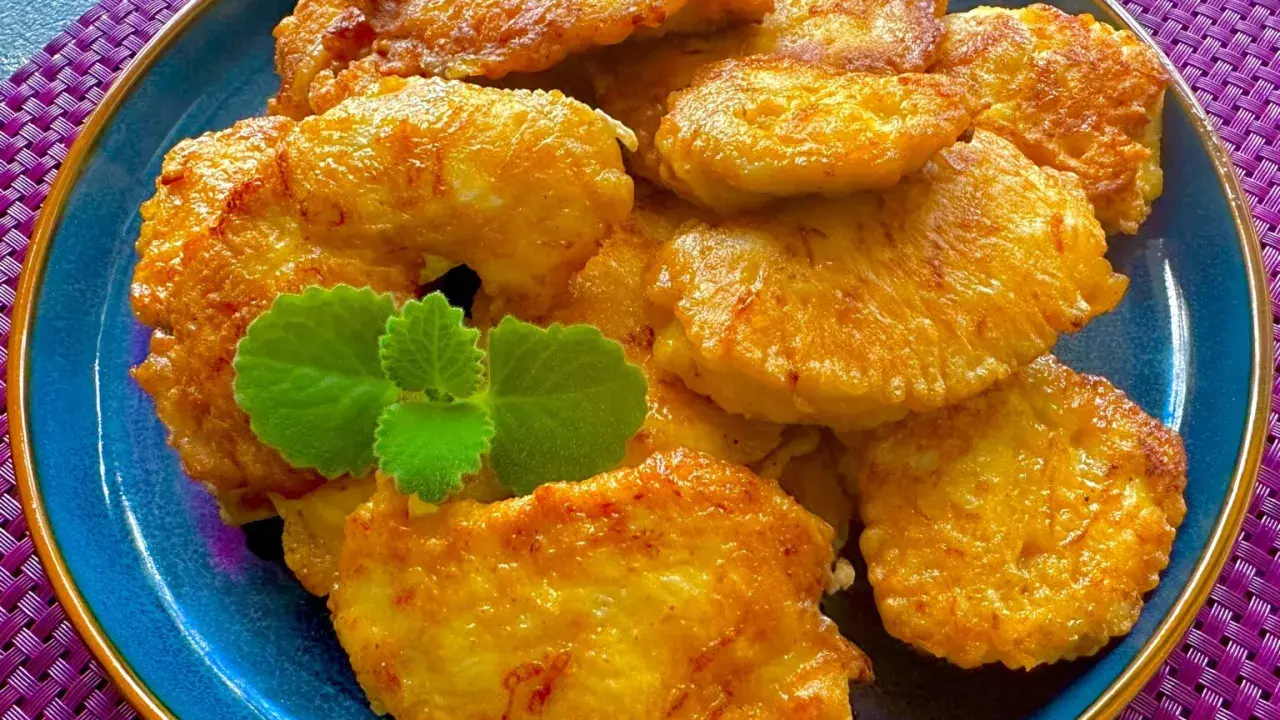 Złociste kotleciki szu szu, chrupiące i aromatyczne, ułożone na niebieskim talerzu, ozdobione listkiem mięty.