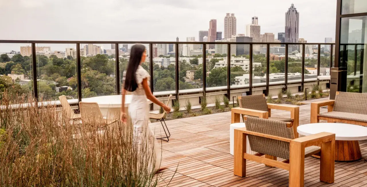 Frauen auf einer Dachterrasse mit Blick auf eine Stadt der kurzen Wege. Moderne Möbel laden zum Verweilen ein.