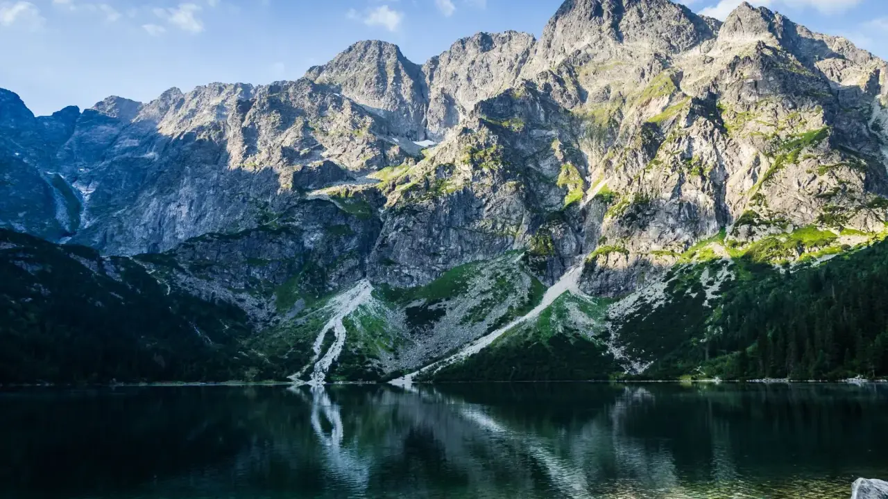 Morskie Oko, Tatry. Majestatyczne góry odbijają się w krystalicznie czystej wodzie, ukazując głębokość jeziora.