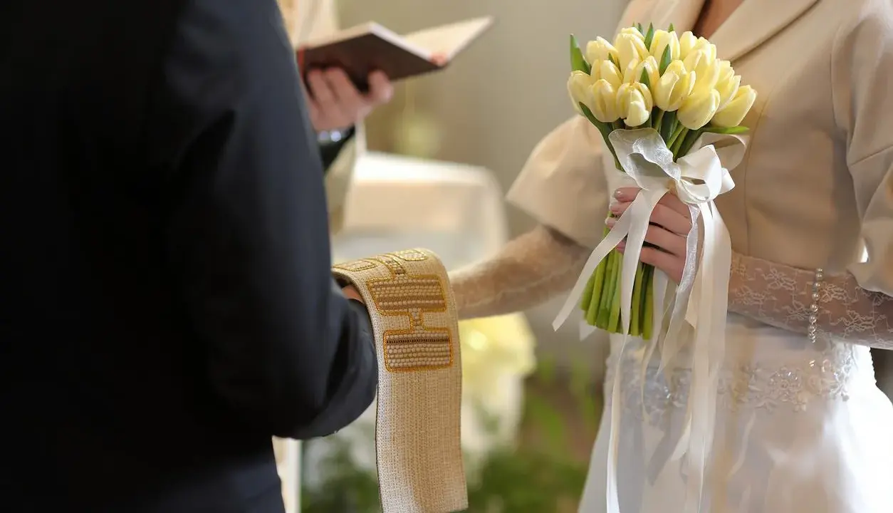 Para młoda trzyma bukiet żółtych tulipanów. Ceremonia ślubna, czy w adwencie można robić wesele?