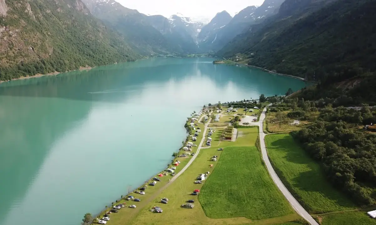Vacker vy över en sjö med berg och campingplatser i Norge. Perfekt för dig som söker campingplatser Norge.