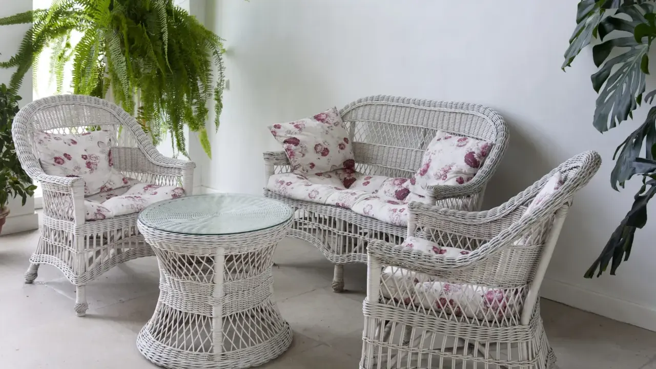 Conjunto de muebles de mimbre blanco con cojines florales, ideal para restaurar muebles de mimbre y darles un toque fresco.