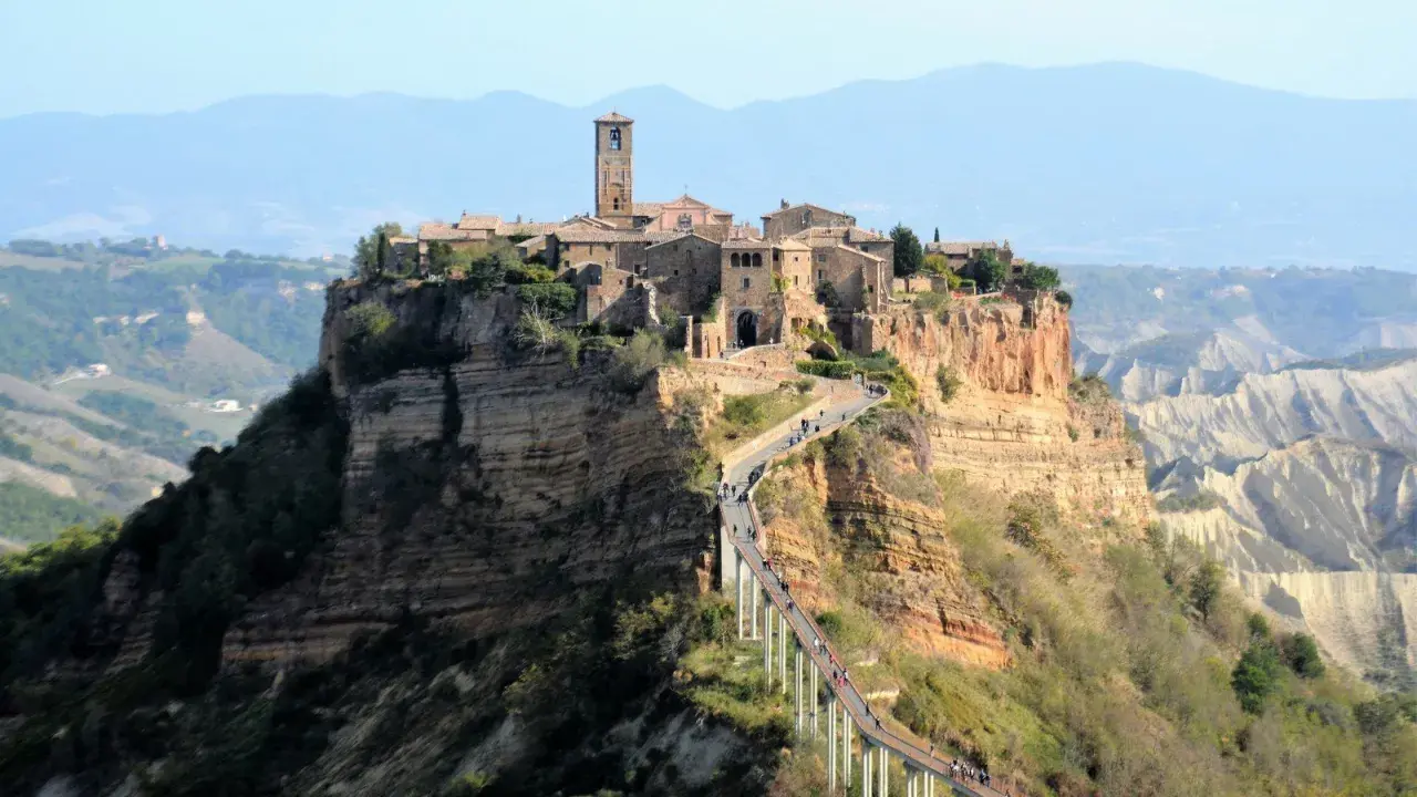 Civita di Bagnoregio, un borgo arroccato su una rupe, è uno dei posti da visitare in Italia. Un ponte pedonale collega il paese alla terraferma.