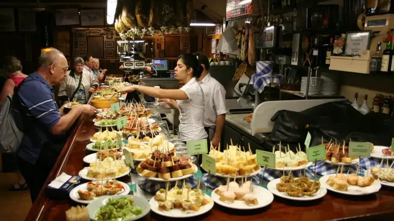 Wybór pysznych tapas na barze, ludzie wybierają przekąski.