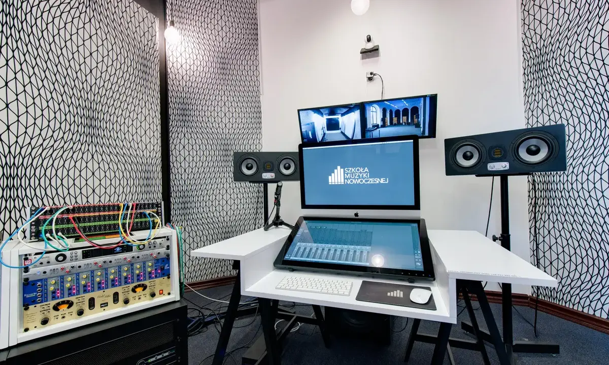 Profesjonalny komputer do muzyki w studiu nagraniowym, z monitorami studyjnymi i rackiem sprzętu audio.