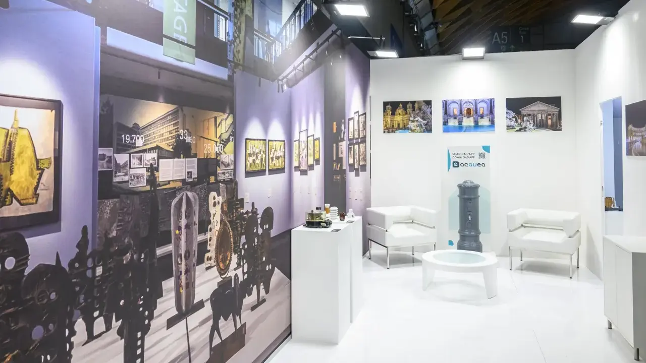 Stand espositivo con opere d'arte e arredi moderni, pronto per il meeting Rimini 2026.