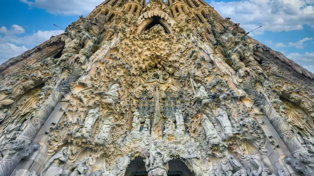 La Sagrada Familia, un capolavoro architettonico, si erge maestosa. La sua facciata è un tripudio di sculture, un racconto visivo che si estende dalla **distanza porto Barcellona Sagrada Familia**.