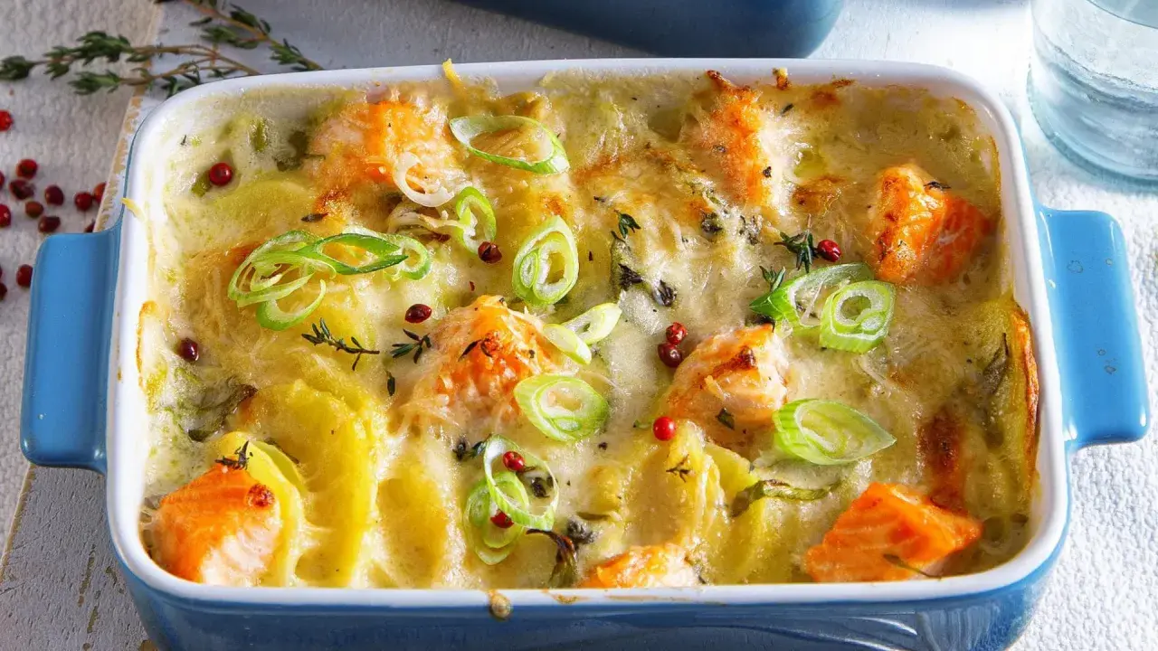 Herzhaftes Fischgericht mit Kartoffeln, überbacken mit Käse und garniert mit Frühlingszwiebeln und rosa Pfeffer.